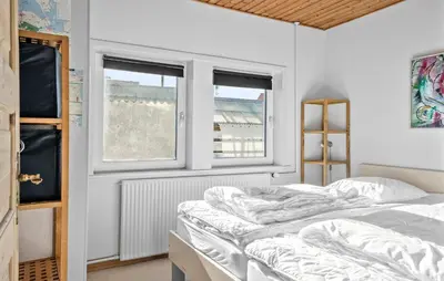 a bedroom with two beds and two windows at Four-Bedroom Holiday Home In Thyboron in Thyborøn