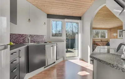 a kitchen with stainless steel appliances and a living room at Cozy Home In Roslev With Wifi in Roslev