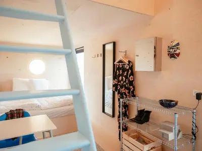 a room with a bunk bed and a ladder at Containerhus 18b in Harboør