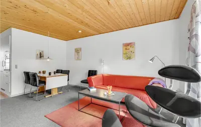 a living room with a red couch and a table at Two-Bedroom Apartment In Lemvig in Lemvig