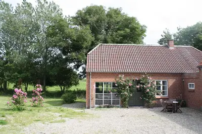 a red brick house with a lot of flowers on it at Rosengave Annekset in Nykøbing Mors