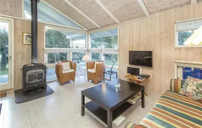 a living room with a couch and a stove at Beautiful Home In Blokhus With Wifi in Blokhus