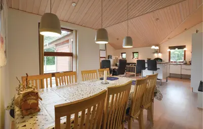 a dining room and kitchen with a table and chairs at Three-Bedroom Holiday Home In Vinderup in Vinderup