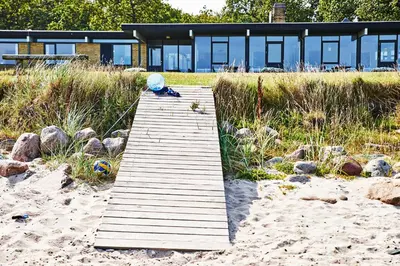 a wooden boardwalk leading to a house on the beach at Danhostel Nykøbing Mors in Nykøbing Mors