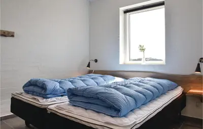 a group of pillows sitting on top of a bed at Nice Home In Thisted With Sauna in Thisted