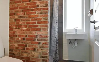a bathroom with a brick wall and a sink at Nice Home In Thisted With Sauna in Thisted
