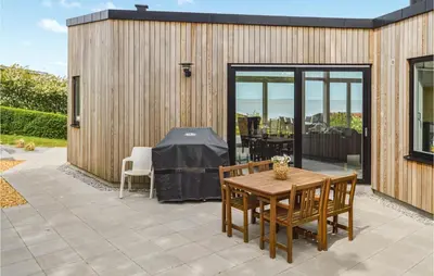 a patio with a table and chairs and a building at Three-Bedroom Holiday Home In Farso in Farsø