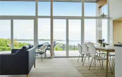 a living room with a table and chairs and a large window at Three-Bedroom Holiday Home In Farso in Farsø