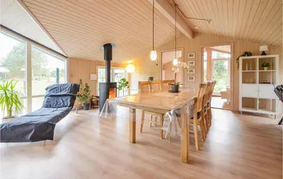 a dining room with a wooden table and chairs at Four-Bedroom Holiday Home In Fjerritslev in Fjerritslev