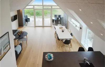a kitchen and living room with a table and chairs at Two-Bedroom Apartment In Thisted in Thisted