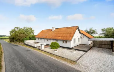 a white house with an orange roof and a road at Two-Bedroom Holiday Home In Spottrup in Spottrup