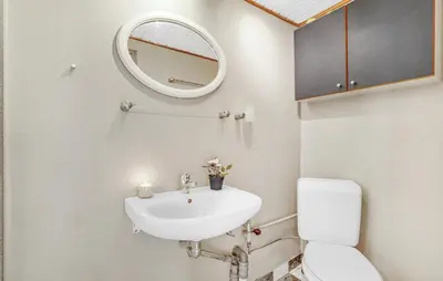 a bathroom with a sink and a mirror and a toilet at Two-Bedroom Holiday Home In Spottrup in Spottrup
