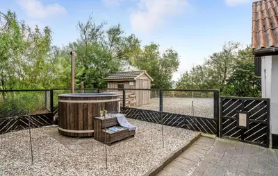 a hot tub in a yard next to a fence at Two-Bedroom Holiday Home In Spottrup in Spottrup