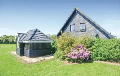 a house with a garden next to a building at Three-Bedroom Holiday Home In Vinderup in Vinderup