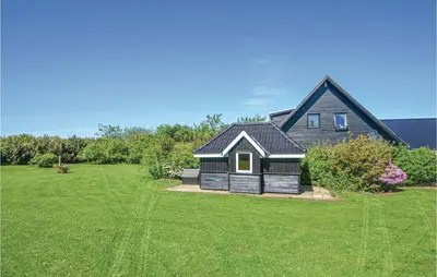 a black house with a large green yard at Three-Bedroom Holiday Home In Vinderup in Vinderup