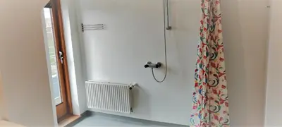 a bathroom with a shower curtain and a window at Feriehus Thy - I hjertet af Thy in Thisted