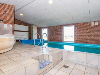 a bathroom with a tub and a swimming pool at 14 person holiday home in Harboøre in Harboør