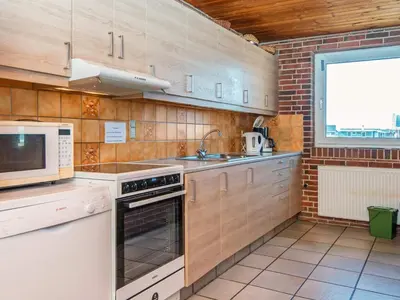 a kitchen with a microwave and a stove top oven at 14 person holiday home in Harboøre in Harboør