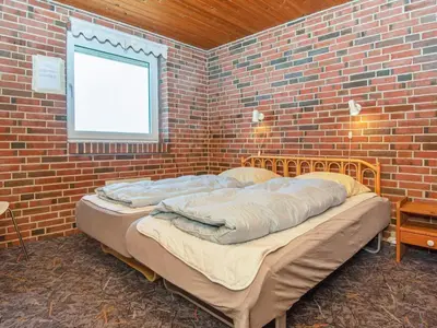 a bedroom with two beds in a brick wall at 14 person holiday home in Harboøre in Harboør