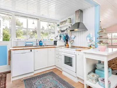 a kitchen with white cabinets and a stove top oven at Holiday Home with Terrace & Fire Pit in Thisted