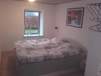 a bed in a room with a window at Lindholt in Fjerritslev