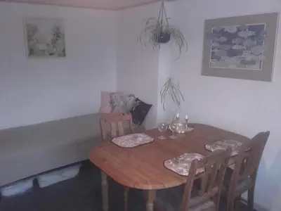 a dining room with a table and chairs and a couch at Lindholt in Fjerritslev