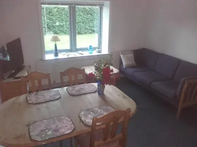 a living room with a wooden table and a couch at Lindholt in Fjerritslev