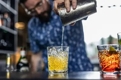 a man is pouring a drink into a glass at Peak 12 Hotel in Viborg
