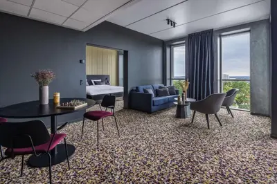 a living room with a bed and a table and chairs at Peak 12 Hotel in Viborg