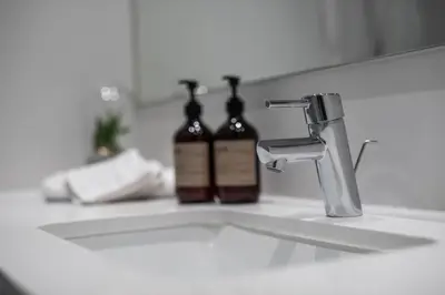 two bottles of soap sitting on a bathroom sink at Peak 12 Hotel in Viborg