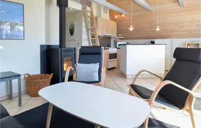 a living room with a table and chairs and a fireplace at 3 Bedroom Awesome Home In Thisted in Thisted