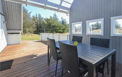 a patio with a table and chairs on a deck at 3 Bedroom Awesome Home In Thisted in Thisted