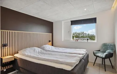a bedroom with a bed and a chair and a window at Amazing Home In Løgstrup With Wifi in Løgstrup