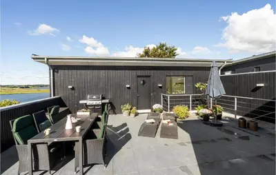 a patio with a table and chairs and a building at Amazing Home In Løgstrup With Wifi in Løgstrup