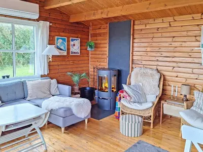 a living room with a couch and chairs and a fireplace at 6 person holiday home in Lemvig in Lemvig