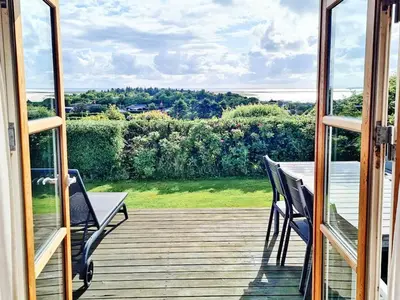 a balcony with a table and chairs on a deck at 6 person holiday home in Lemvig in Lemvig