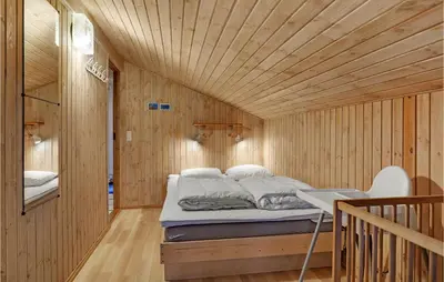 a bed in a wooden room with a wooden ceiling at 4 Bedroom Beautiful Home In Saltum in Saltum