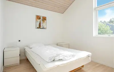 a white bedroom with a bed and a window at Beautiful Home In Blokhus With Kitchen in Blokhus