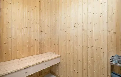a wooden paneled wall with a wooden bench in a sauna at Beautiful Home In Blokhus With Kitchen in Blokhus