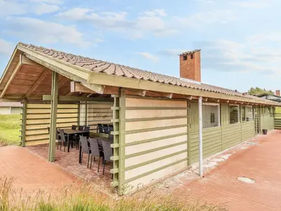 awning over a patio with a table and chairs at Type2 holiday home in Hanstholm in Hanstholm