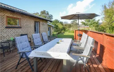 a table and chairs with an umbrella on a deck at 3 Bedroom Cozy Home In Fur in Fur