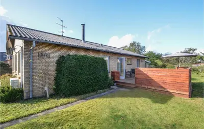 a brick house with a wooden fence next to a yard at 3 Bedroom Cozy Home In Fur in Fur