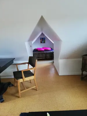 a room with a bed and a chair and a table at Hunetorpvej Holiday Apartment in Blokhus