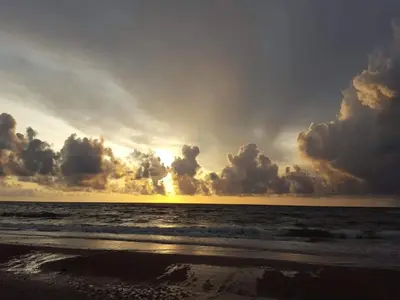 a sunset on the beach with the ocean at 6 person holiday home in Brovst in Brovst