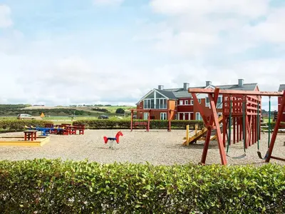 a playground with a slide and a swing set at 5 person holiday home on a holiday park in Lemvig in Lemvig