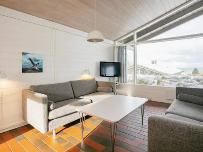 a living room with a couch and a table and a tv at Room in Vigsø Holiday Park in Hanstholm
