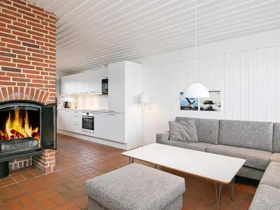 a living room with a couch and a fireplace at Modern comfort holiday home in Hanstholm