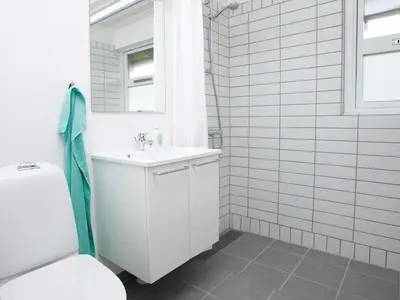 a white bathroom with a sink and a toilet at Modern comfort holiday home in Hanstholm