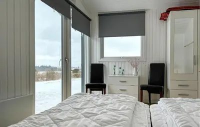 a bedroom with two beds and two chairs and a window at 3 Bedroom Stunning Home In Snedsted in Snedsted