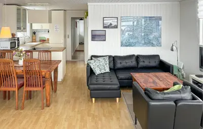 a living room with a black leather couch and a table at 3 Bedroom Stunning Home In Snedsted in Snedsted